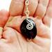 Handmade Amethyst keychain with silver wire wrap, shown close up and resting in an open hand for scale.